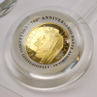 Moneta 500 Lire Dante Alighieri in oro osservata sotto una lente di cristallo